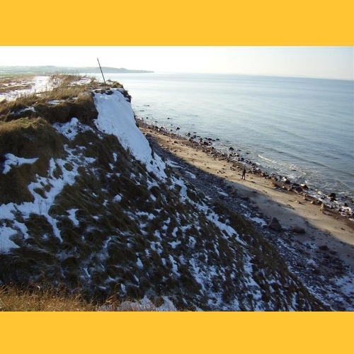 Wenn man genau hinsieht: Am Strand geht ein Mensch. Erst so sieht man, wie hoch die Steilk�ste hier ist.